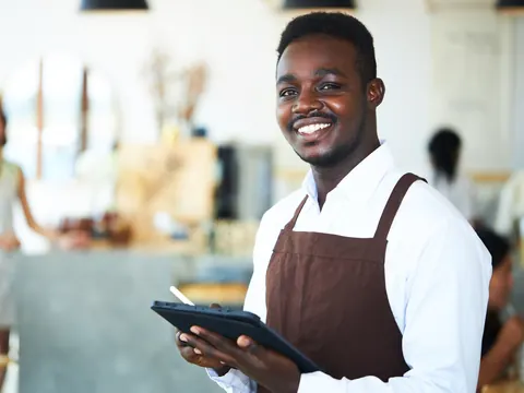 Atendente de restaurante com tablet de reservas na mão